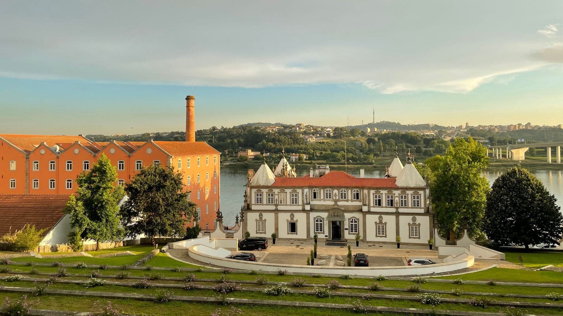 Elegante edificio di villa bianca con tetto in terracotta che si affaccia sul fiume Douro a Porto, immerso nei giardini e adiacente a una cantina di vino Porto.