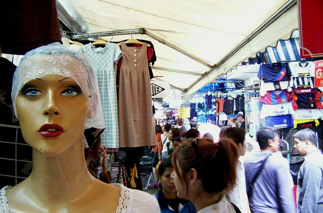 Étals bondés du marché de Pratunam à Bangkok avec vêtements et acheteurs