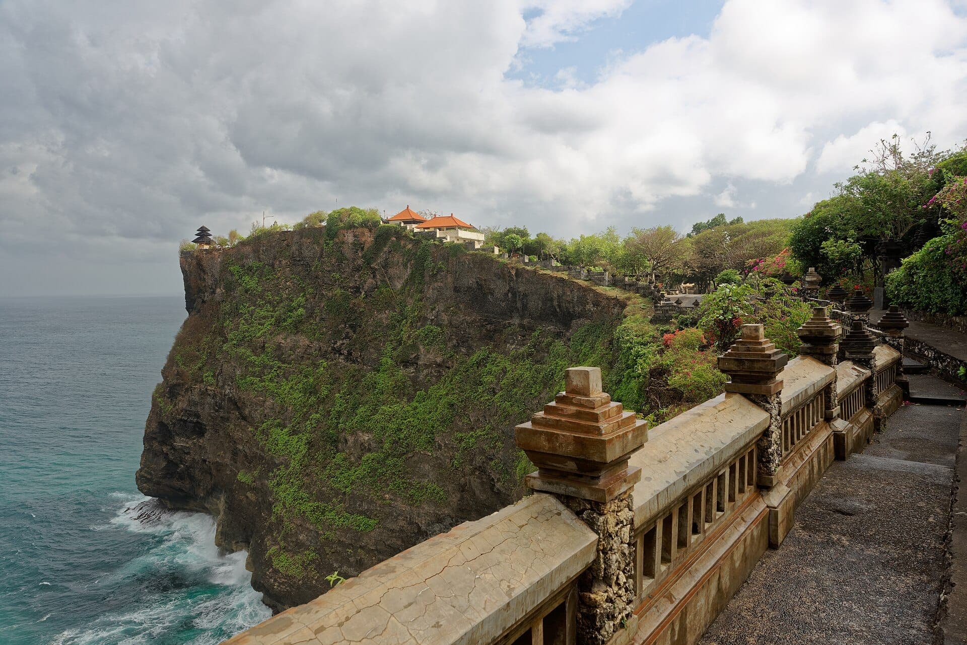 Pura Luhur Uluwatu temple perched on a dramatic 70-meter cliff overlooking crashing Indian Ocean waves in Bali.