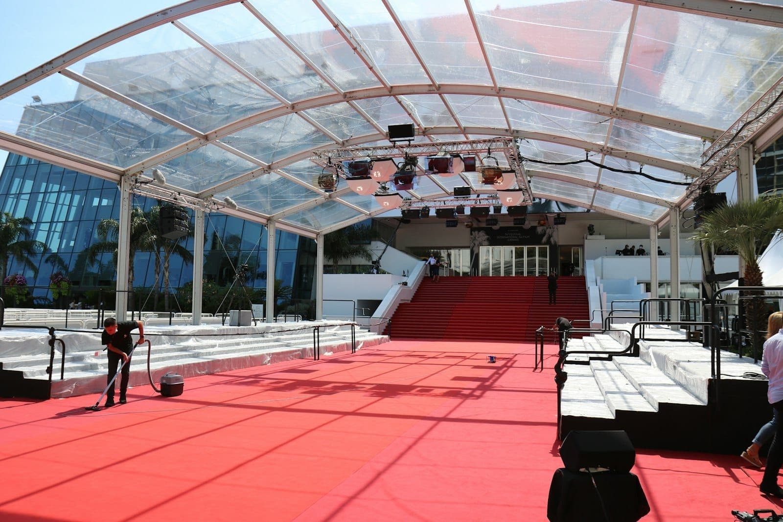 Вид на культовые ступени Montée des Marches с красной ковровой дорожкой у Palais des Festivals в Каннах со стеклянным навесом и трибунами.