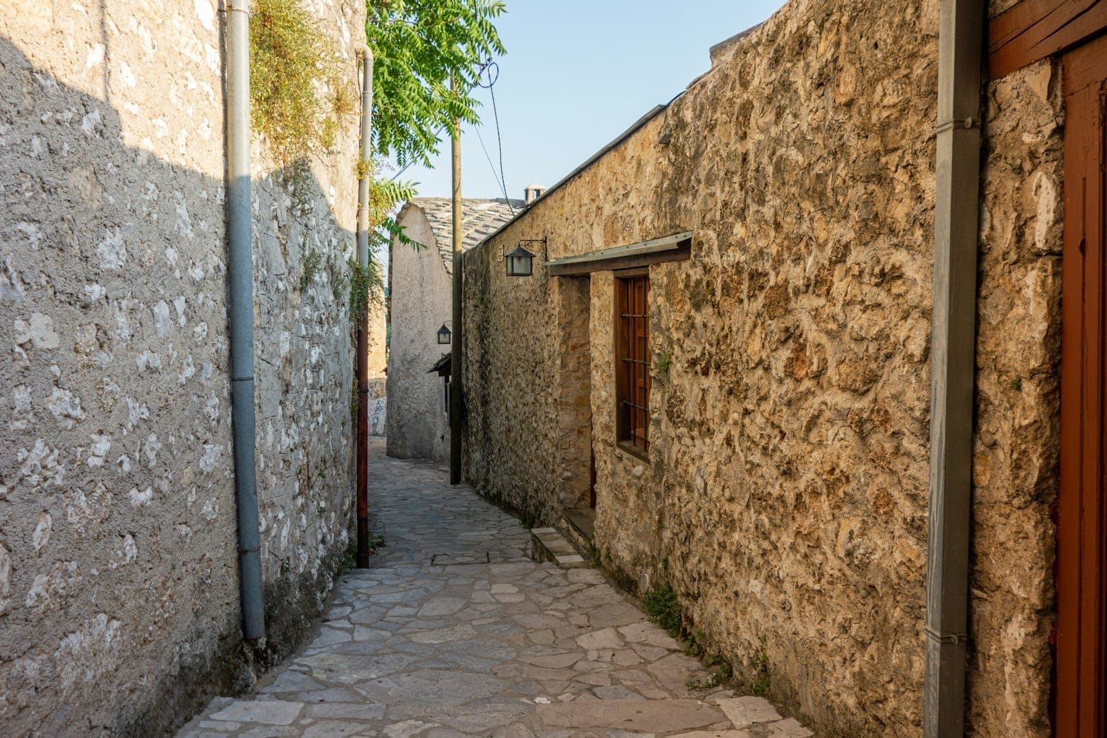 Ruelle étroite en pierre avec des bâtiments d'hébergement traditionnel bon marché, le soleil projetant des ombres dans un quartier de la vieille ville de Rhodes.