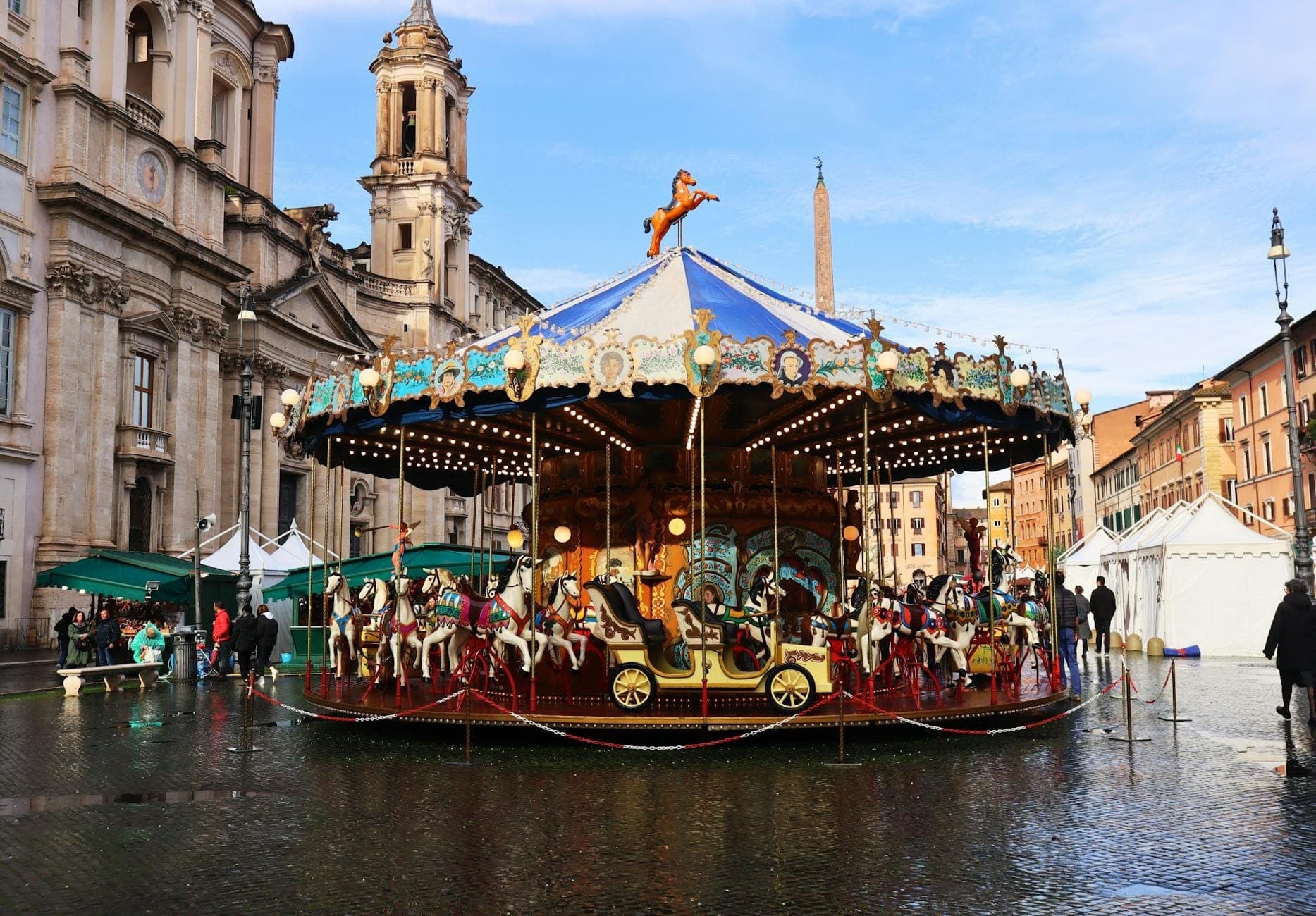 Makulay na carousel na may mga kabayo sa Piazza Navona sa Roma, napapaligiran ng makasaysayang arkitektura at masayang kapaligiran — perpekto para sa mga pamilyang may kasamang mga bata.