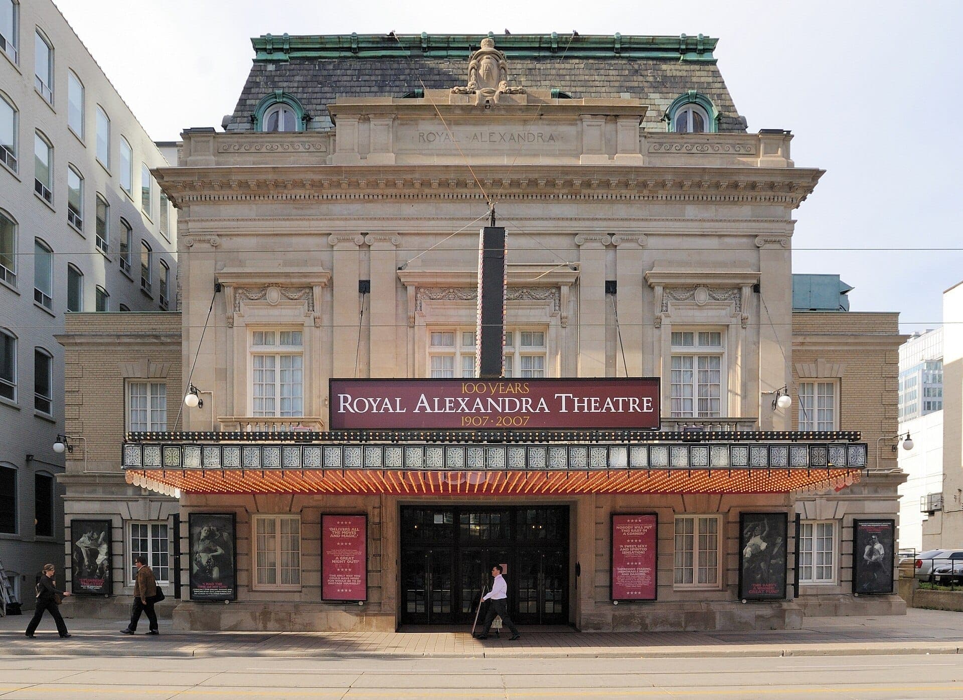Vista frontale dello storico Royal Alexandra Theatre a Toronto, con la sua ornata facciata in stile Beaux-Arts e le grandi luci dell'insegna durante il giorno.