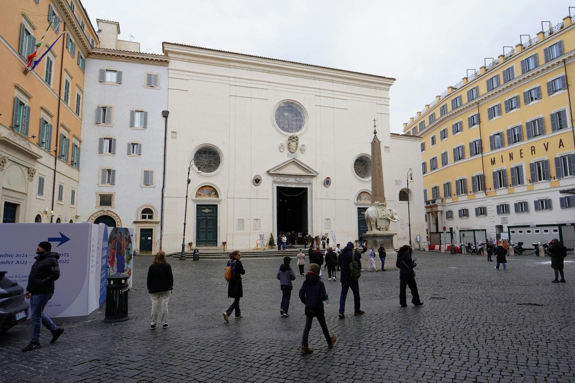 Malawak na tingin sa Basilica di Santa Maria sopra Minerva kasama ang elepanteng obelisko ni Bernini at mga tao sa plasa sa harap ng simbahan.