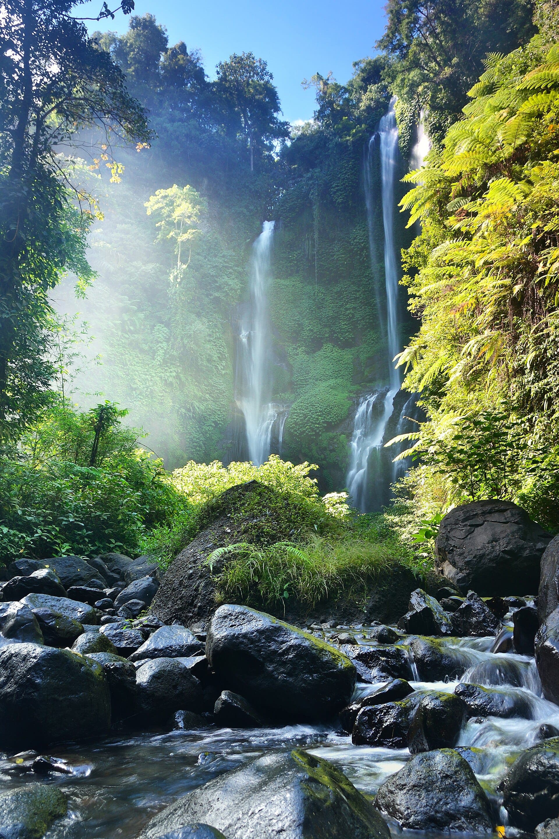 Sekumpul Waterfall, Bali's tallest, features twin powerful streams plunging through verdant northern Bali valleys amid deep-green foliage.