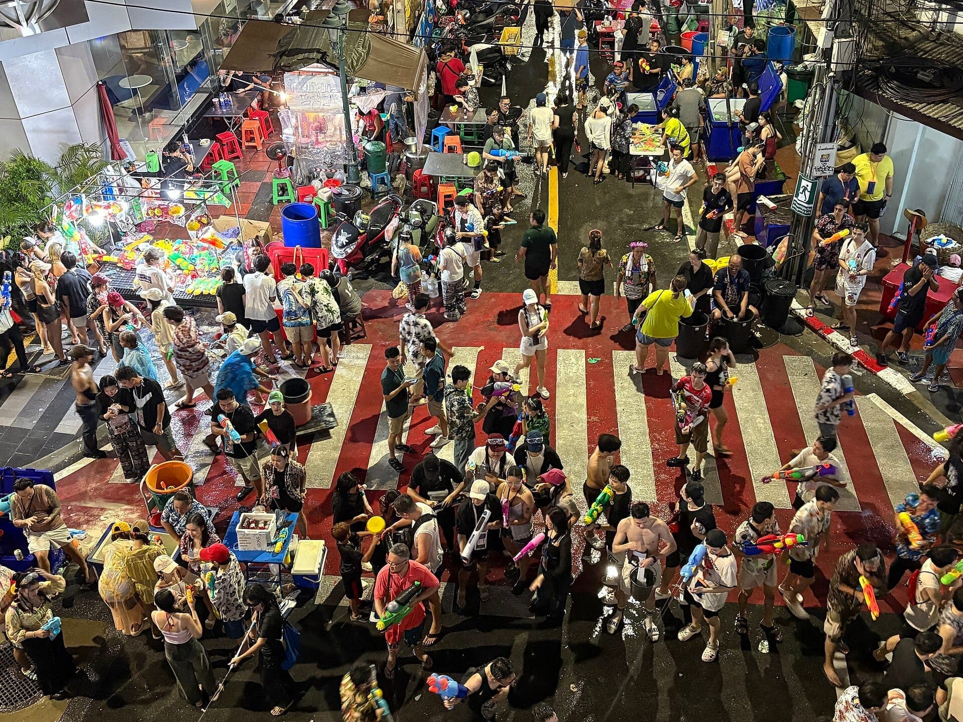 Толпы людей празднуют Сонгкран на Силом-роуд в Бангкоке — водные бои, уличные лотки и атмосфера ночной жизни