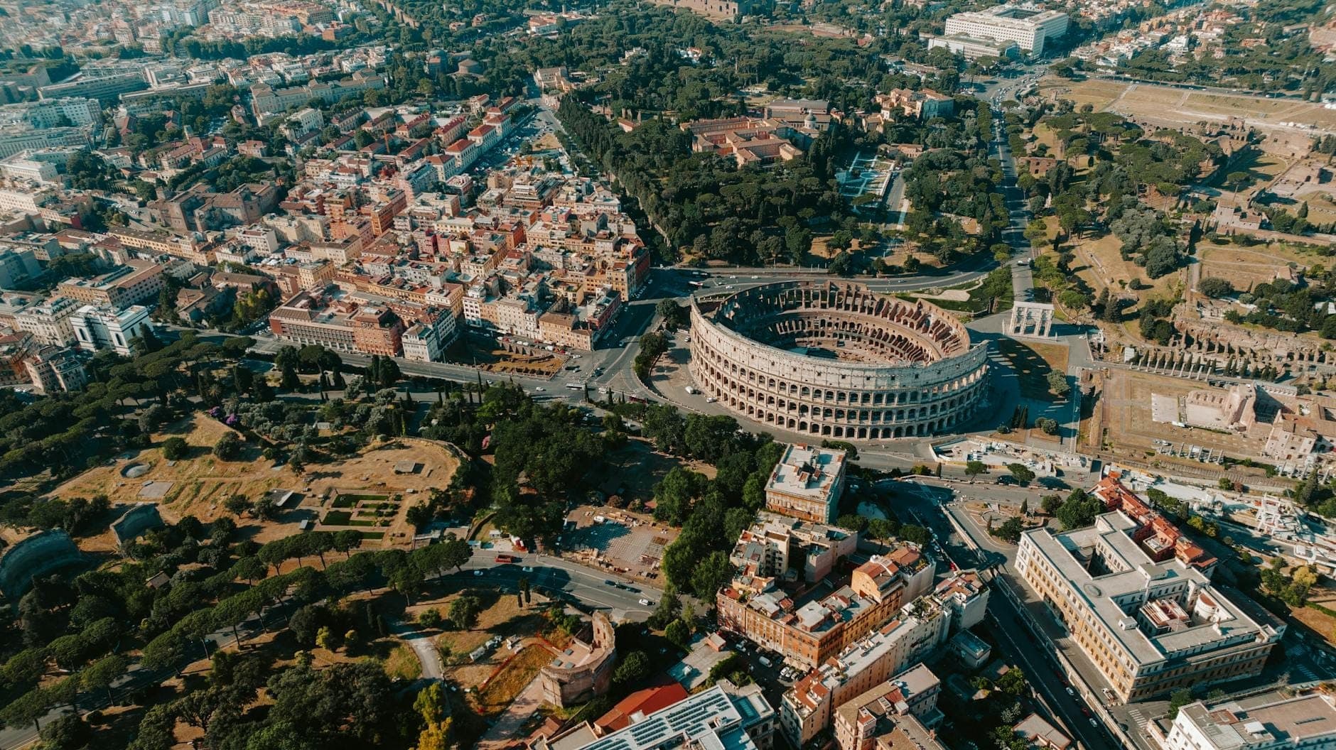 Vista aerea del Colosseo e del centro storico di Roma in una giornata di sole.