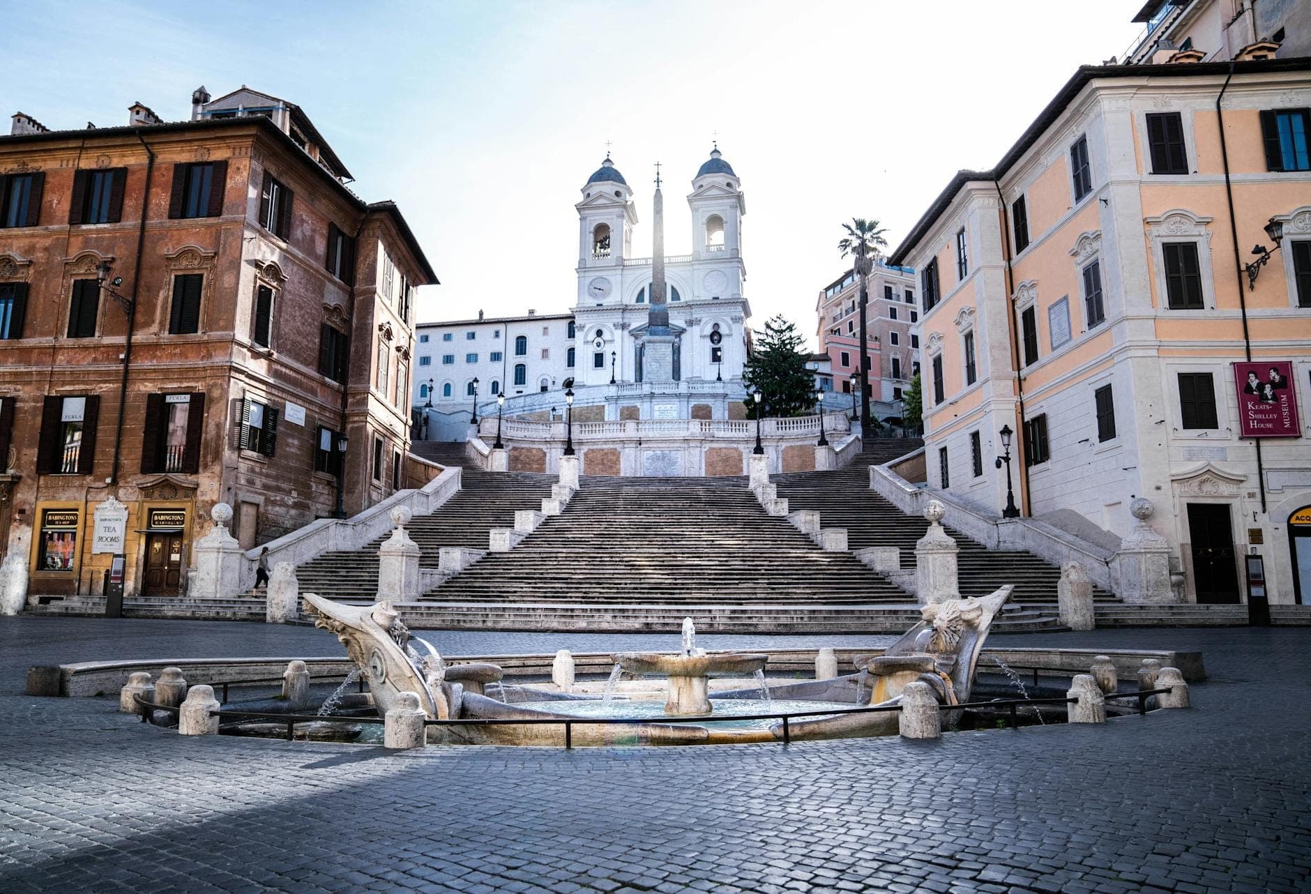 Malawak, maliwanag na tanawin ng Spanish Steps pataas patungo sa simbahang Trinità dei Monti sa Roma, kasama ang Barcaccia Fountain at walang taong plaza sa ibaba.