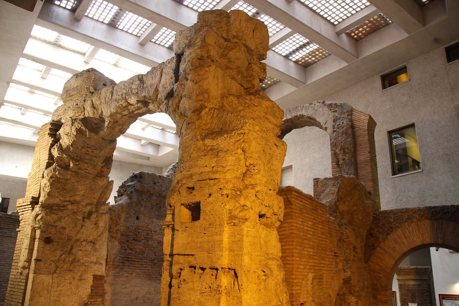 Mga sinaunang arko ng tisa at bato ng mga guho ng Stadium of Domitian, niliwanagan ng malambot na panloob na ilaw sa ilalim ng modernong kisame na may skylight.