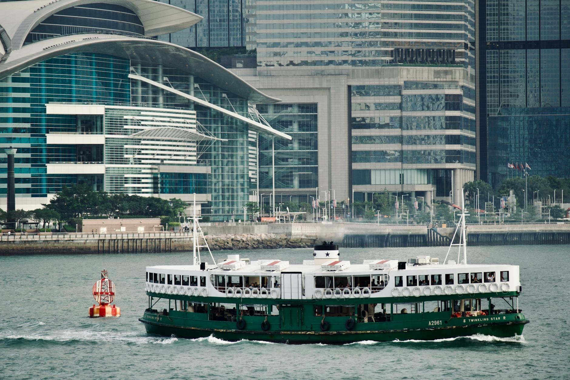 Iconic Star Ferry gliding across Victoria Harbour in Hong Kong with skyscrapers in the background.
