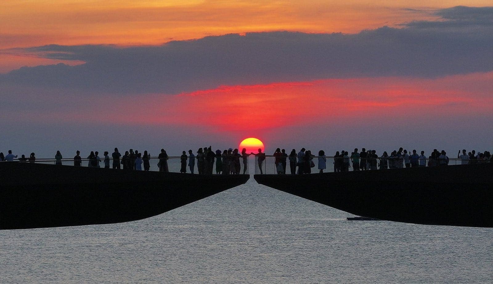 Le Kiss Bridge (Cầu Hôn) à Sunset Town Phu Quoc avec la foule admirant le coucher de soleil sur la mer entre les deux plateformes