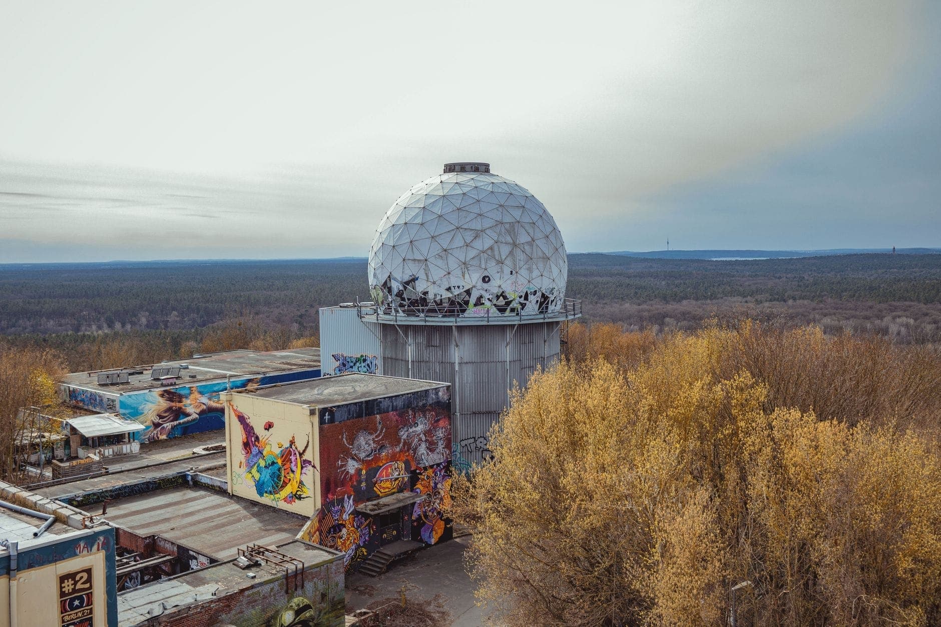 สถานีสอดแนม Teufelsberg กับโดมเรดาร์ทรงกลมสีขาว บนยอดตึกเก่าสะพานกราฟฟิตี้ รายล้อมด้วยต้นไม้และป่าใต้ฟ้าครึ้ม