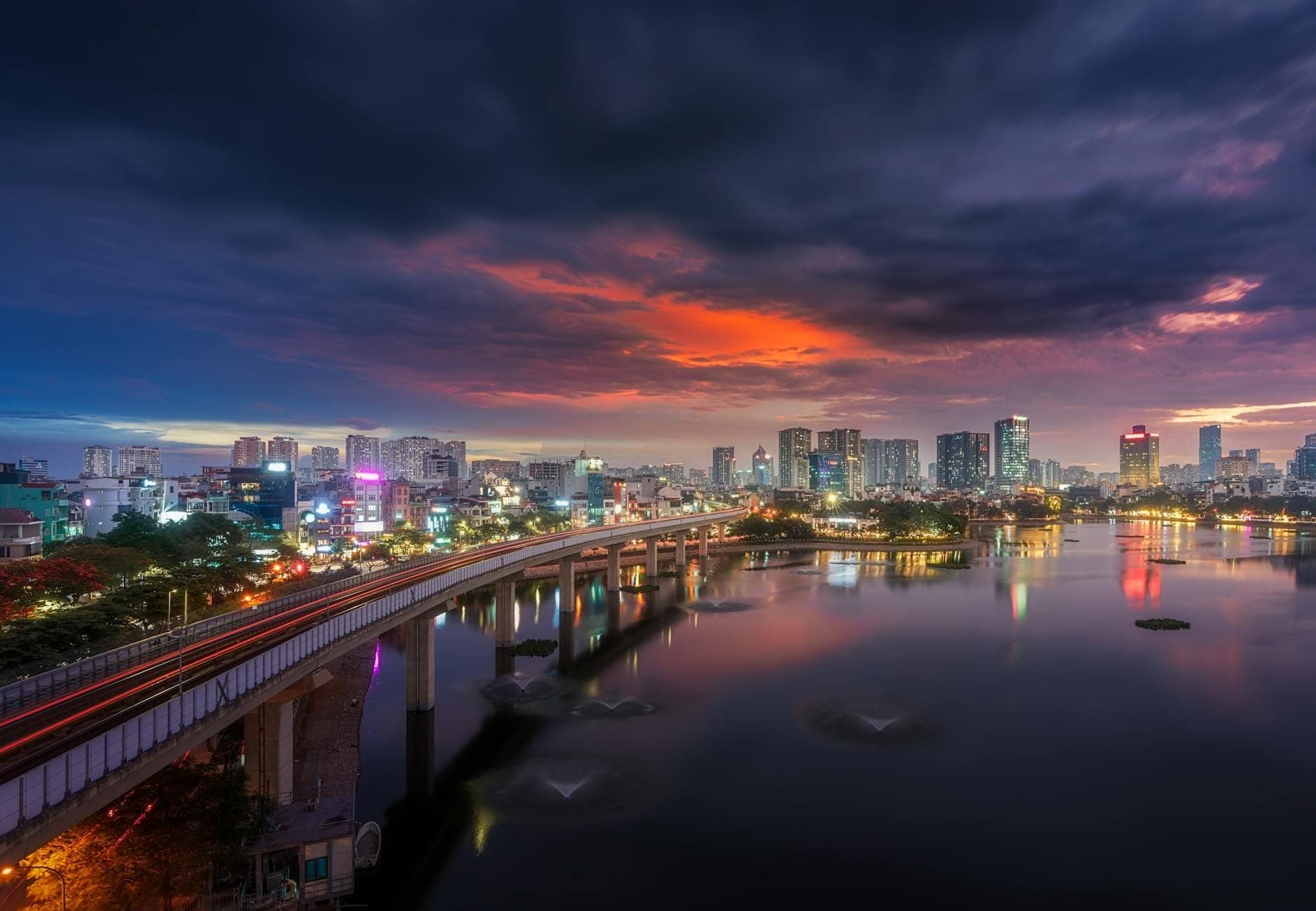 Coucher de soleil sur le Chao Phraya à Thonburi avec pont et skyline de Bangkok