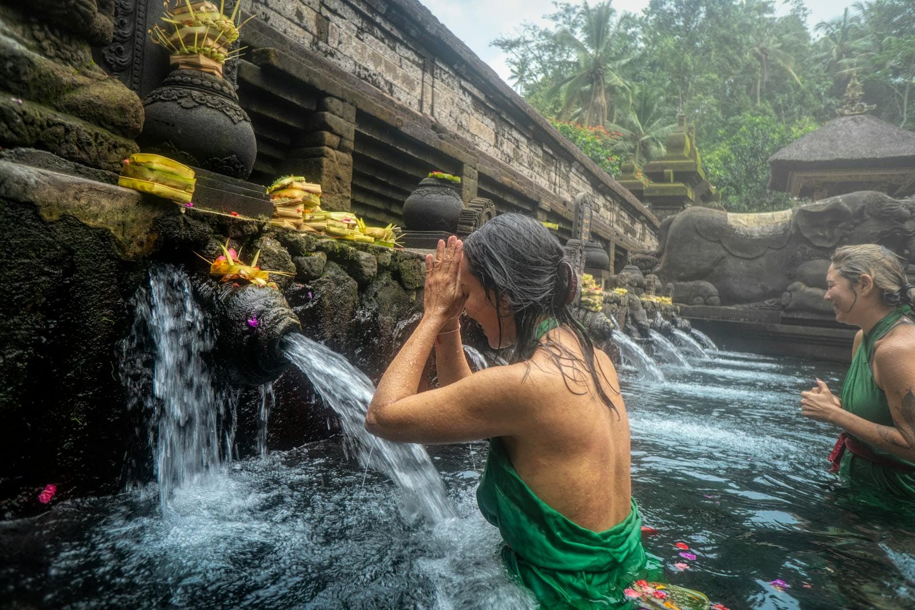 Visitors performing ritual purification bathing at Tirta Empul Temple's holy water springs in Tampaksiring