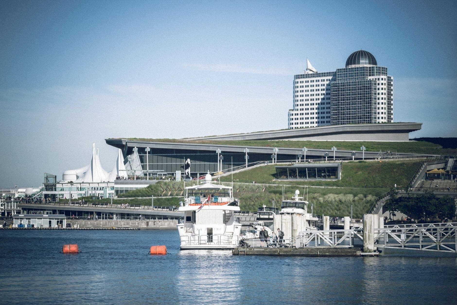 วิวของ Vancouver Convention Centre พร้อมใบเรือของ Canada Place และท่าจอดเรือพร้อมเรือในเบื้องหน้า