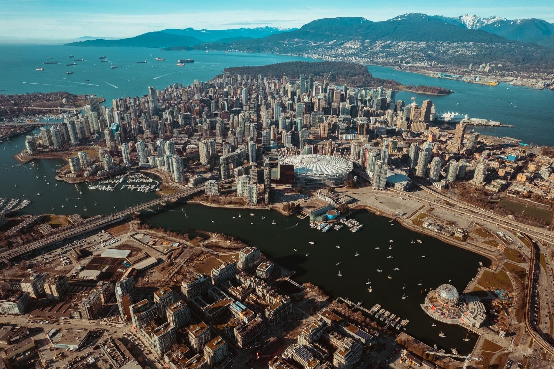 มุมมองทางอากาศของ Vancouver พร้อมเส้นขอบฟ้าของเมือง ริมน้ำ และภูเขา โดยเน้นเส้นทางการเดินทางหลักไปทางใต้