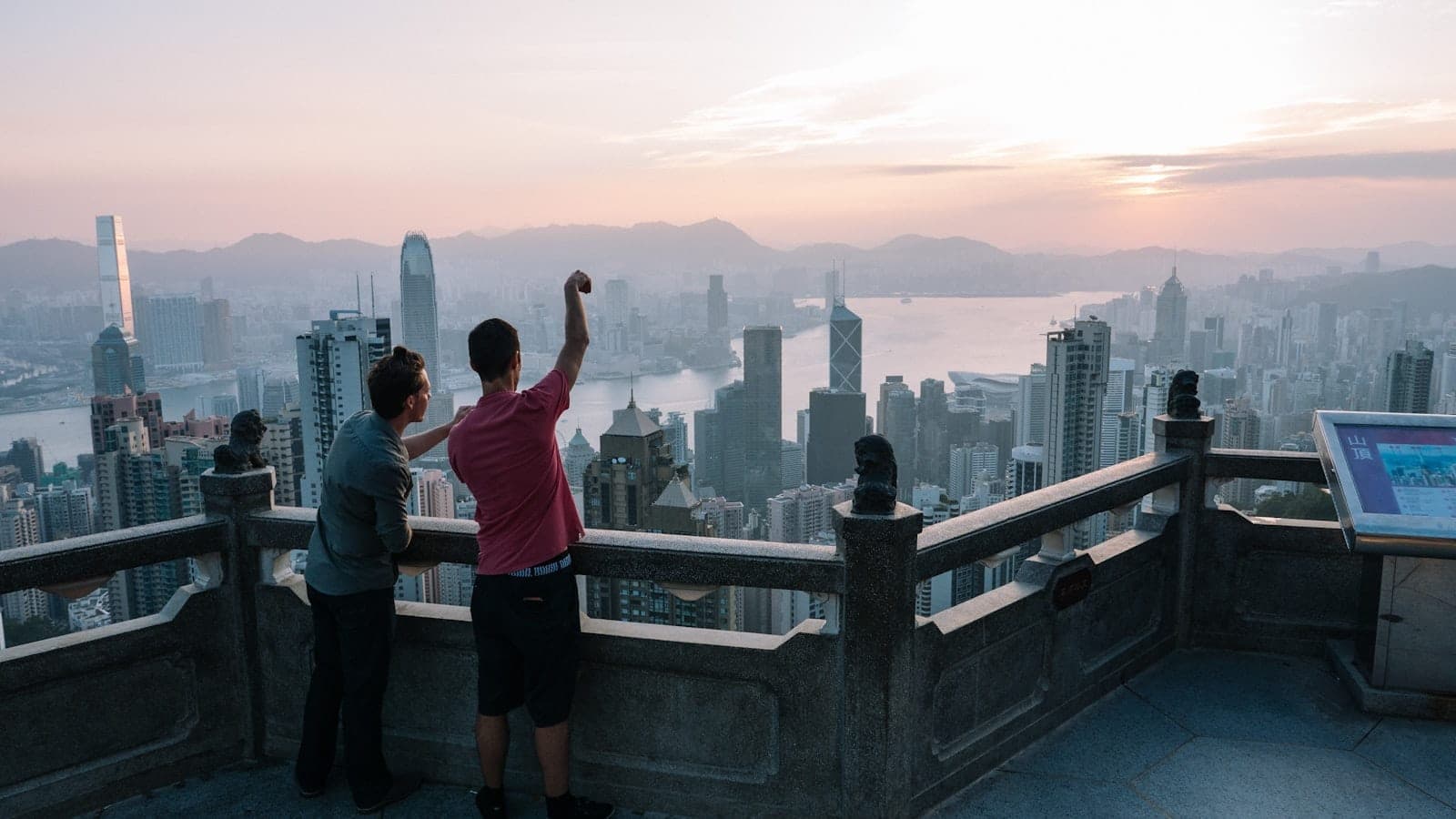 Panoramic view of Victoria Peak overlooking Hong Kong's skyline, Victoria Harbour, and surrounding islands during daytime