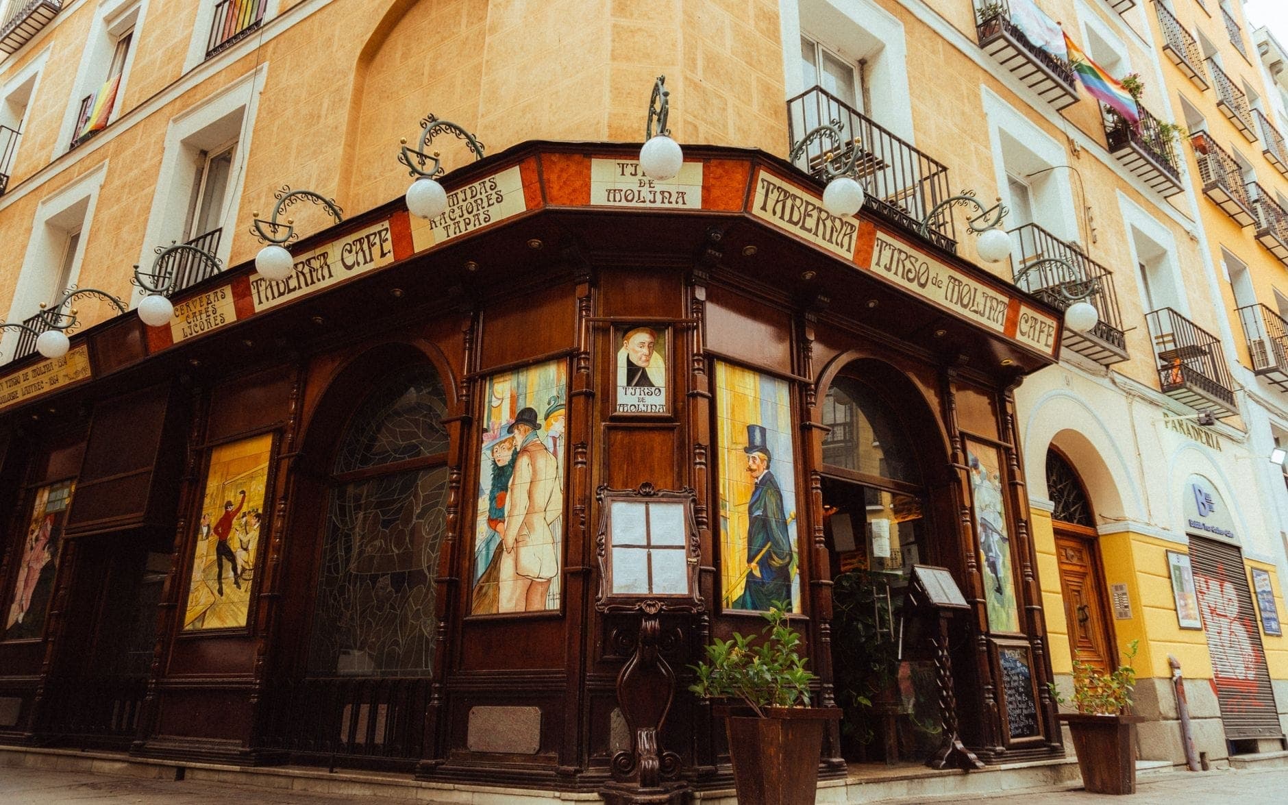 Eckansicht einer traditionellen Madrider Taverne mit Holzfassade, historischen Schildern und bemalten Fenstern in einer charmanten alten Straße.