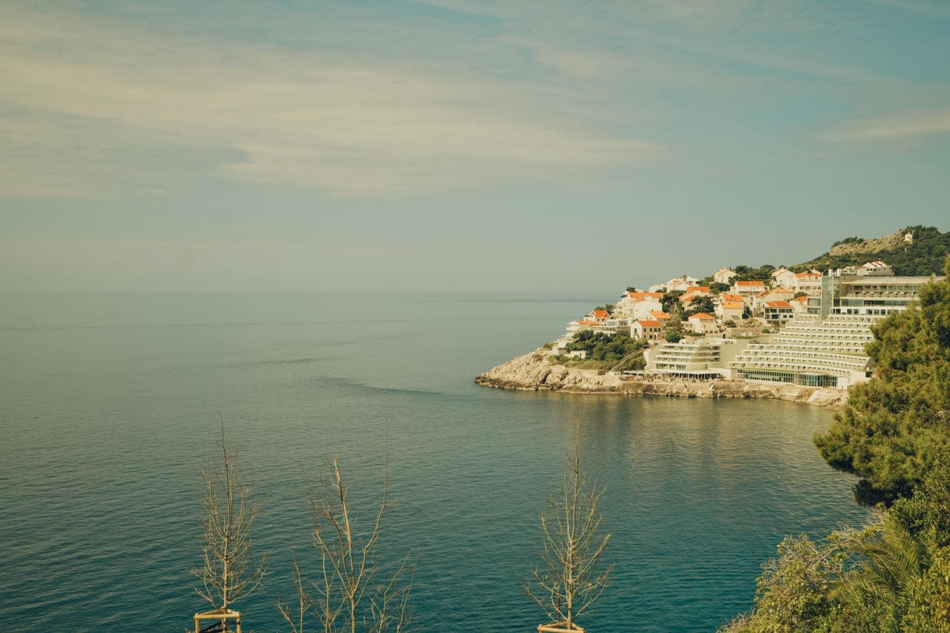 Pemandangan kawasan Ploče di Dubrovnik dengan hotel dan vila yang berjejer di pantai Adriatik, dilihat dari sisi perairan pada hari yang cerah.
