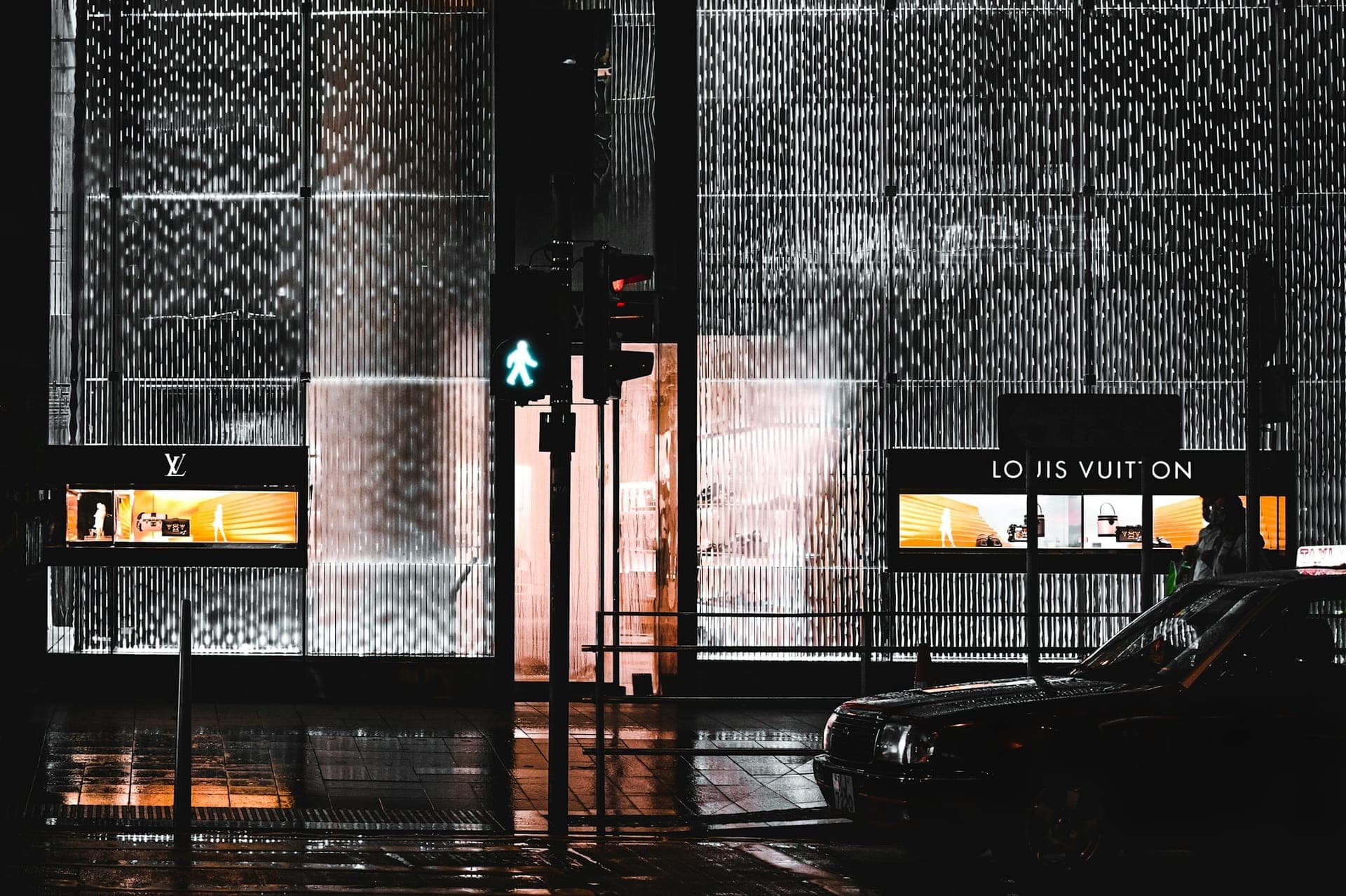 Luxury retail storefront in Hong Kong at night with illuminated glass facade