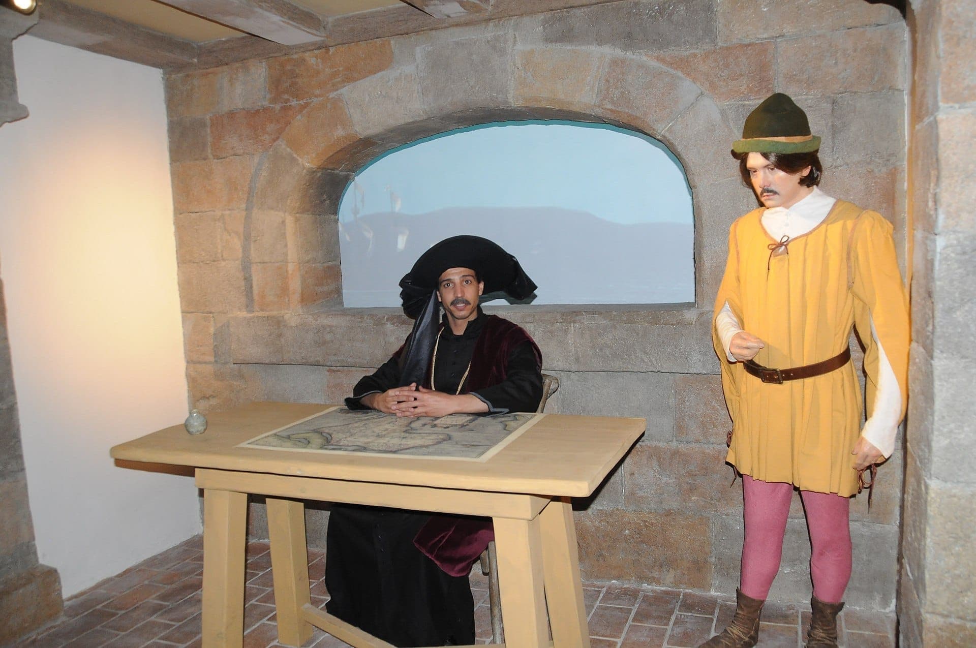 Mannequins réalistes habillés en explorateurs portugais avec des vêtements d'époque dans une exposition aux murs de pierre au musée World of Discoveries de Porto.