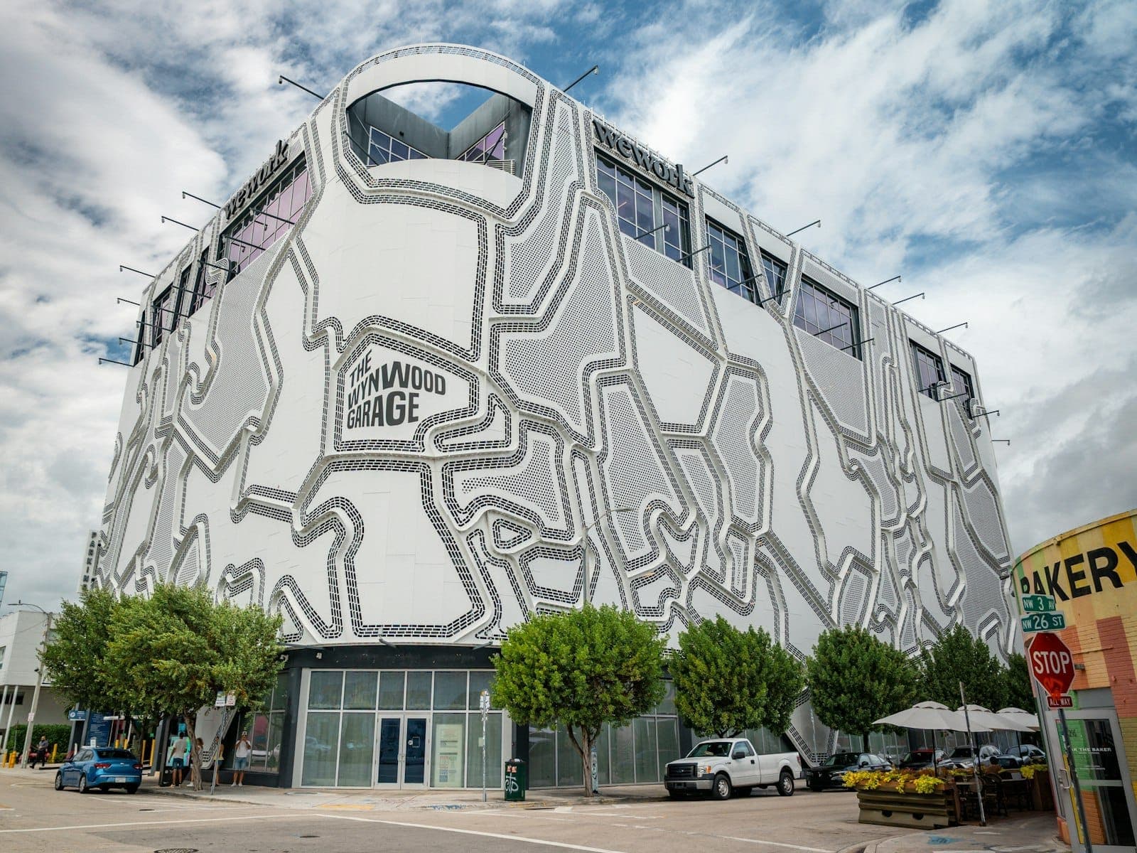 Bâtiment Wynwood Garage avec façade géométrique distinctive à côté d'arbres et d'une rue de la ville à Miami