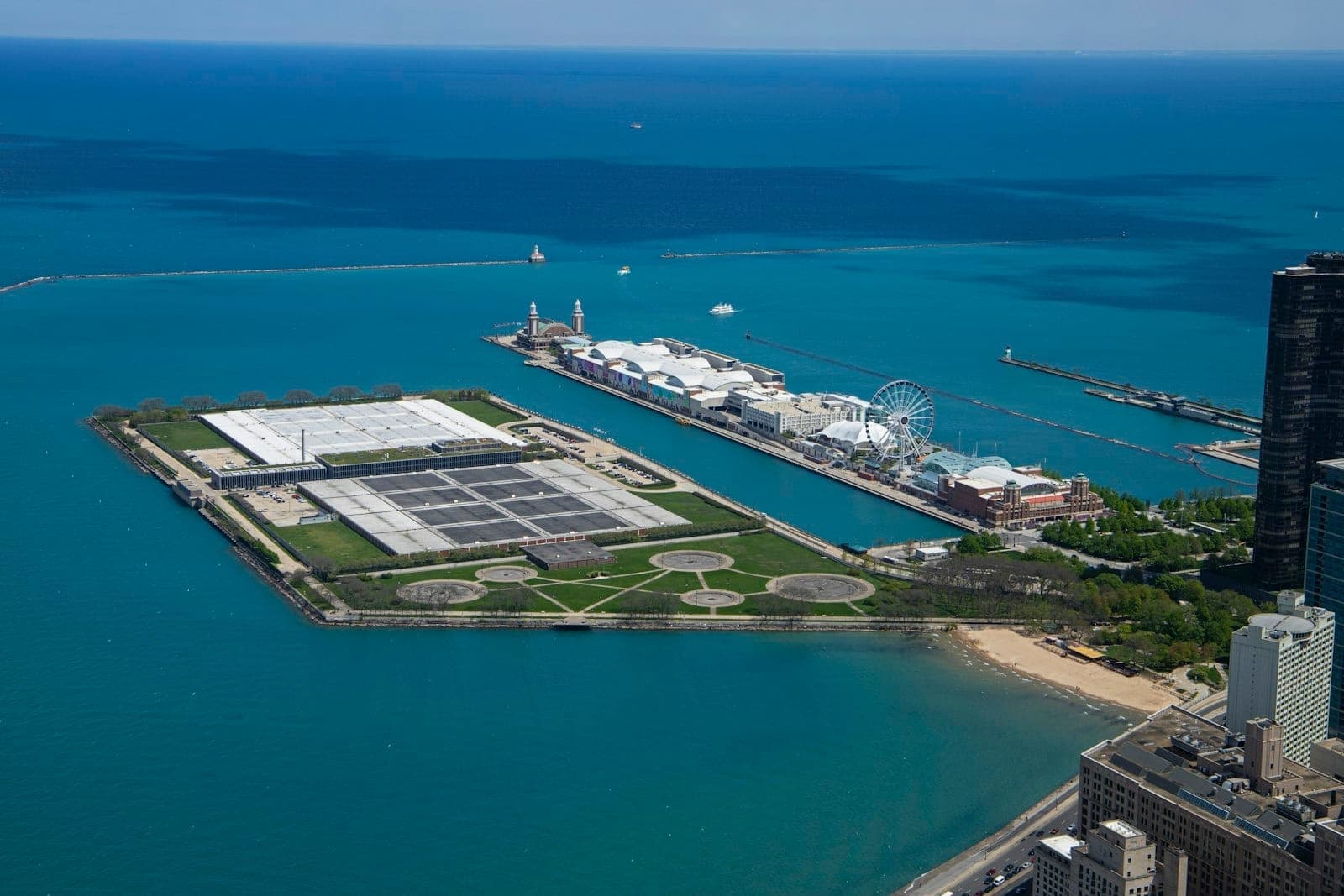 Vista aérea del Navy Pier extendiéndose hacia el lago Michigan con la noria, el agua azul y el horizonte de Chicago.