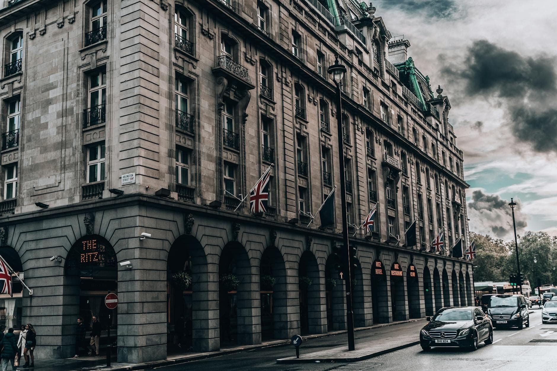 Vista dalla strada dell'esterno dell'hotel The Ritz London con bandiere britanniche e architettura classica in una giornata nuvolosa