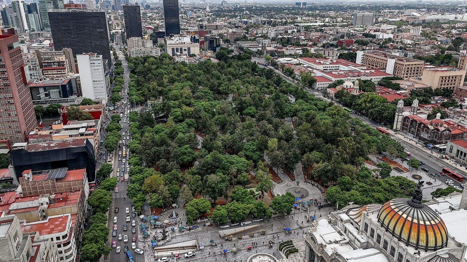 มุมมองทางอากาศของสวน Alameda Central ที่ล้อมรอบด้วยถนนในเมือง อาคารประวัติศาสตร์ และ Palacio de Bellas Artes ในใจกลางเมือง Mexico City