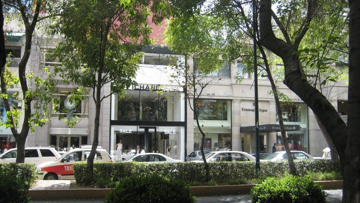 Avenida Presidente Masaryk ที่เรียงรายด้วยบูติกหรูหราและต้นไม้ร่มรื่น พร้อมทางเท้าที่คึกคัก รถจอดริมถนน และนักเดินทางในยามบ่ายที่แสงแดดสดใส