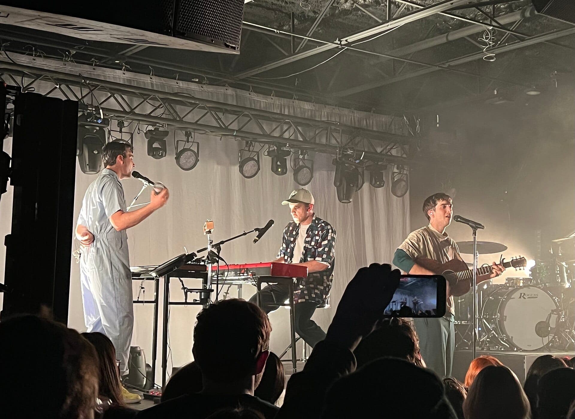 A band performs on stage at The Basement East in Nashville, with keyboards, guitar, stage lights, and an engaged audience in the foreground.