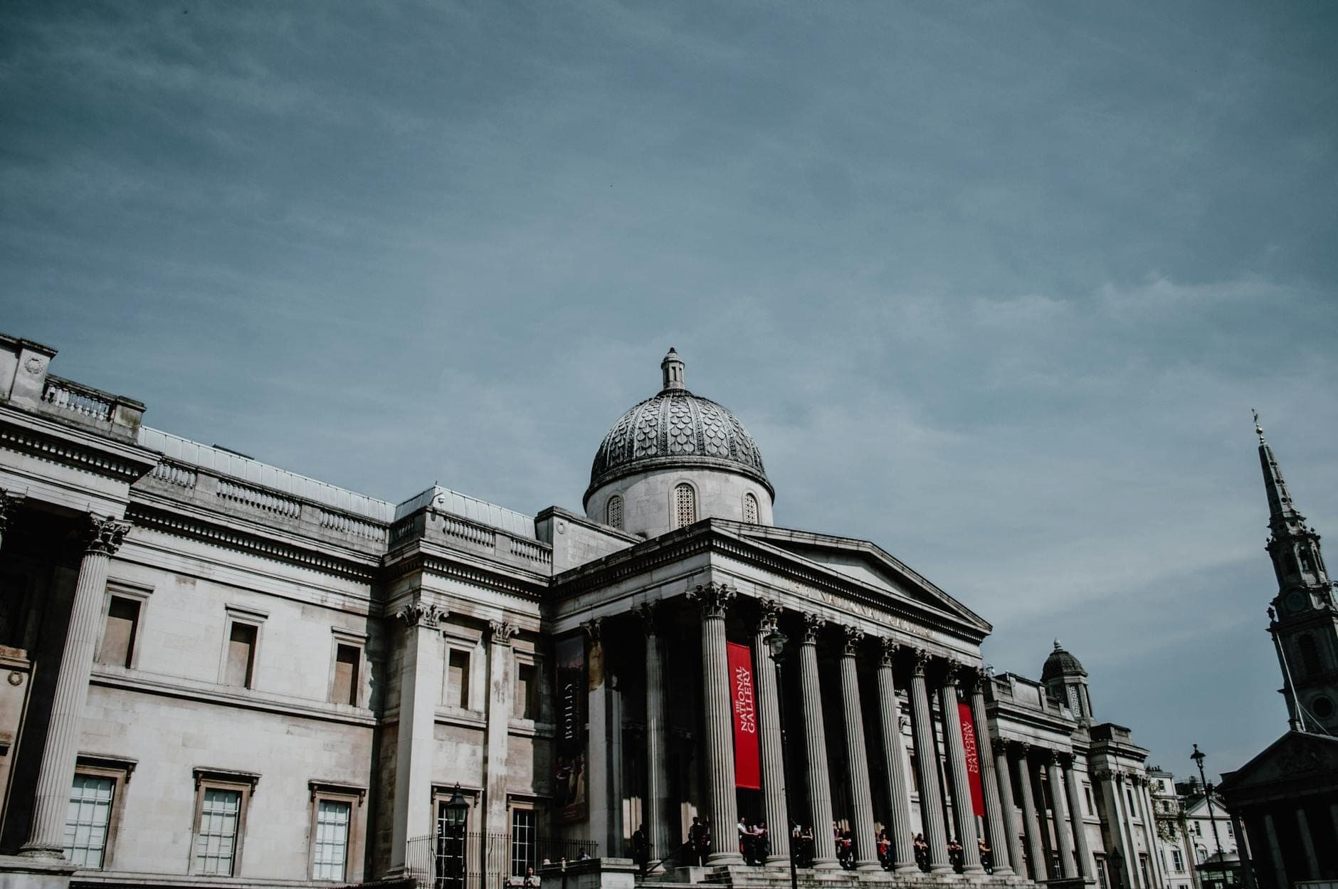 Die prächtige neoklassizistische Fassade der National Gallery in London mit hohen Säulen und Kuppel unter einem klaren Himmel.