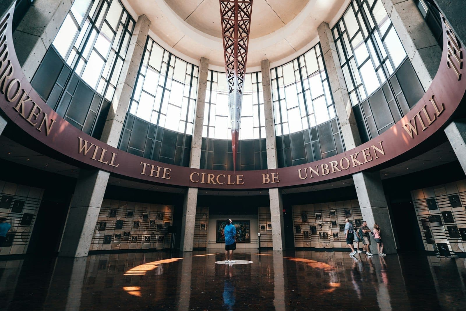The grand rotunda of the Country Music Hall of Fame in Nashville with people exploring the circular, sunlit hall and museum exhibits.