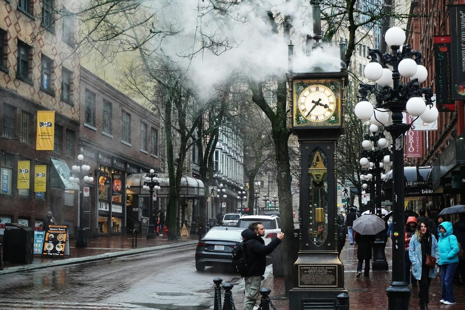 นาฬิกาไอน้ำ Gastown ในเมือง Vancouver วันฤดูหนาวที่มีฝนตก ผู้คนถือร่มและถนนเปียกชื้น