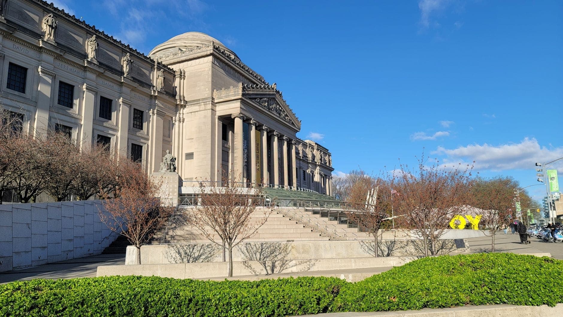 ด้านนอกของ Brooklyn Museum ยามแดดจ้า โดดเด่นด้วยสถาปัตยกรรม Beaux-Arts และบันไดหินขนาดใหญ่