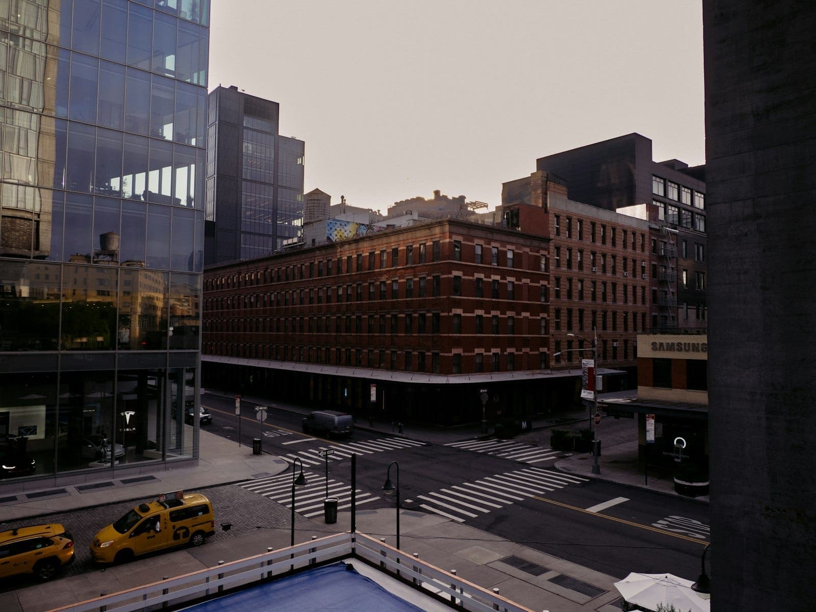 วิวยามเช้าตรู่ของ Chelsea และ Meatpacking District พร้อมโกดังอิฐ อาคารกระจกสมัยใหม่ แท็กซี่สีเหลือง และถนนในเมืองที่เงียบสงบ