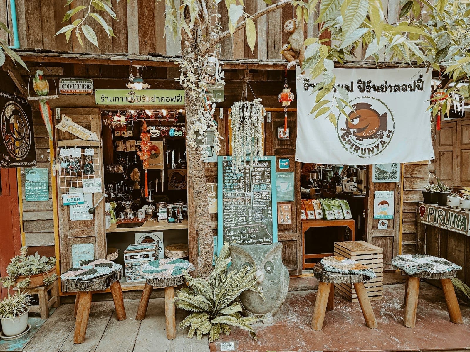 Affascinante caffè rustico con decorazioni artigianali, posti a sedere all'aperto e segnaletica creativa nel quartiere creativo di Chiang Mai.