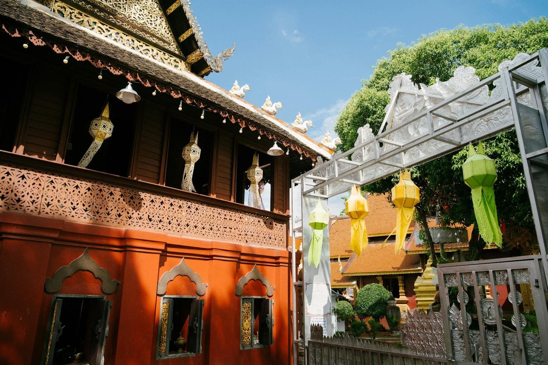 Holzgebäude mit traditionellen Laternen und bunten Papierlaternen, die außen hängen, was auf einen kreativen oder kulturellen Raum in Chiang Mai hindeutet.