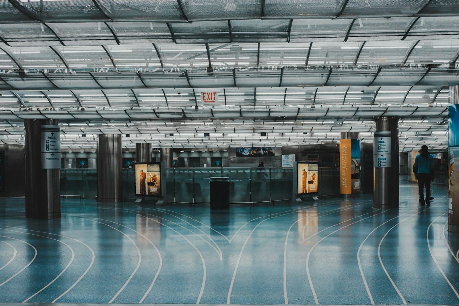 Modernes, geräumiges Inneres eines Passagierterminals am Flughafen O'Hare mit blauem Boden und beleuchtetem Decke, das das Layout des Flughafens und die Passagierbewegungsbereiche widerspiegelt.