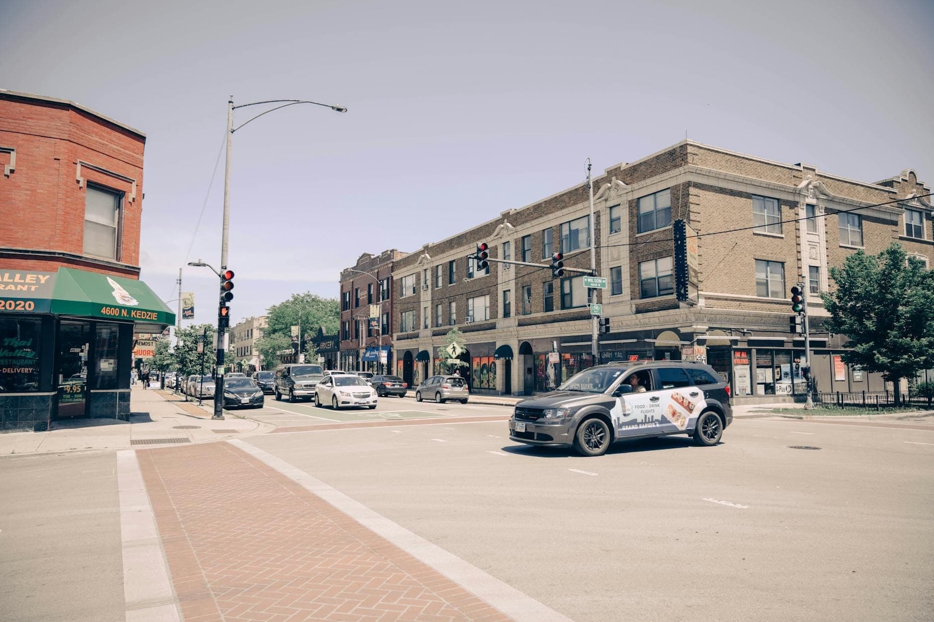 Chicago street corner with historic brick buildings, shops, and traffic, capturing a sense of classic city neighborhood atmosphere.