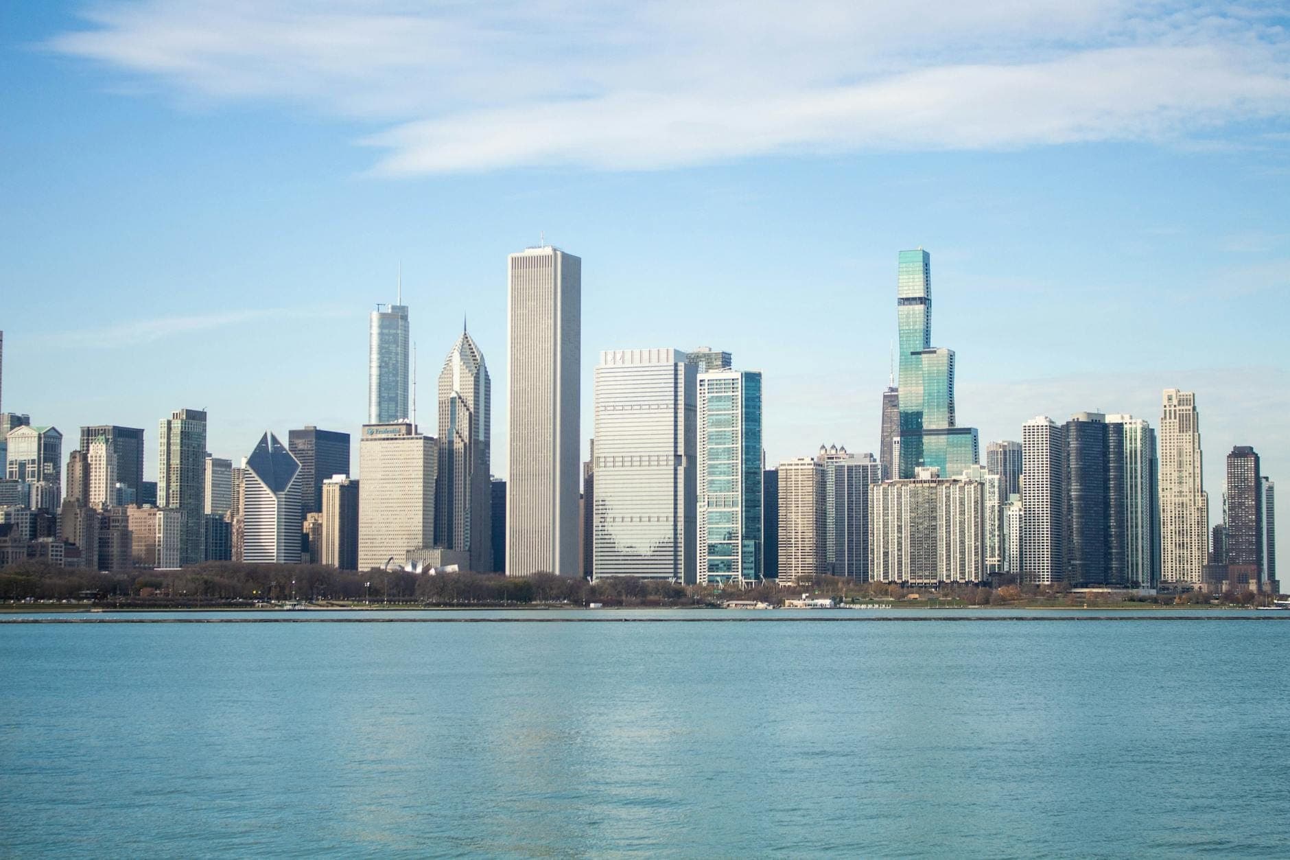 Daytime view of Chicago skyline from Lake Michigan with prominent skyscrapers and clear blue sky.