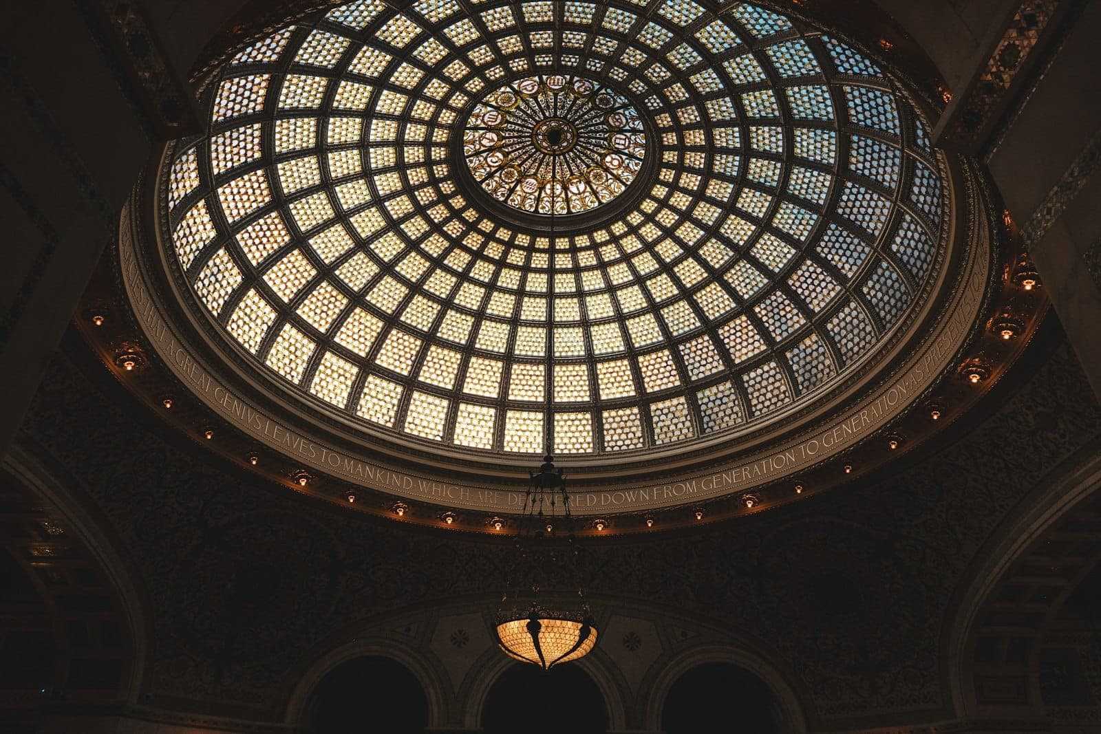 ภายใน Chicago Cultural Center กับโดมกระจก Tiffany ขนาดใหญ่ลวดลายวิจิตรและโคมระย้าห้อยใจกลาง โอบล้อมด้วยสถาปัตยกรรม Beaux-Arts สุดคลาสสิก