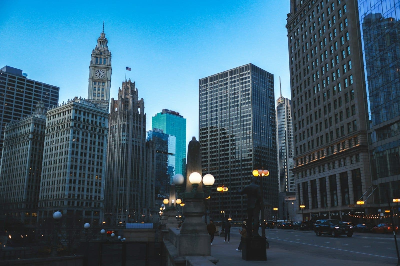 Iconic Chicago skyscrapers along Michigan Avenue at dusk, including historic high-rises and street lights near the Chicago River.