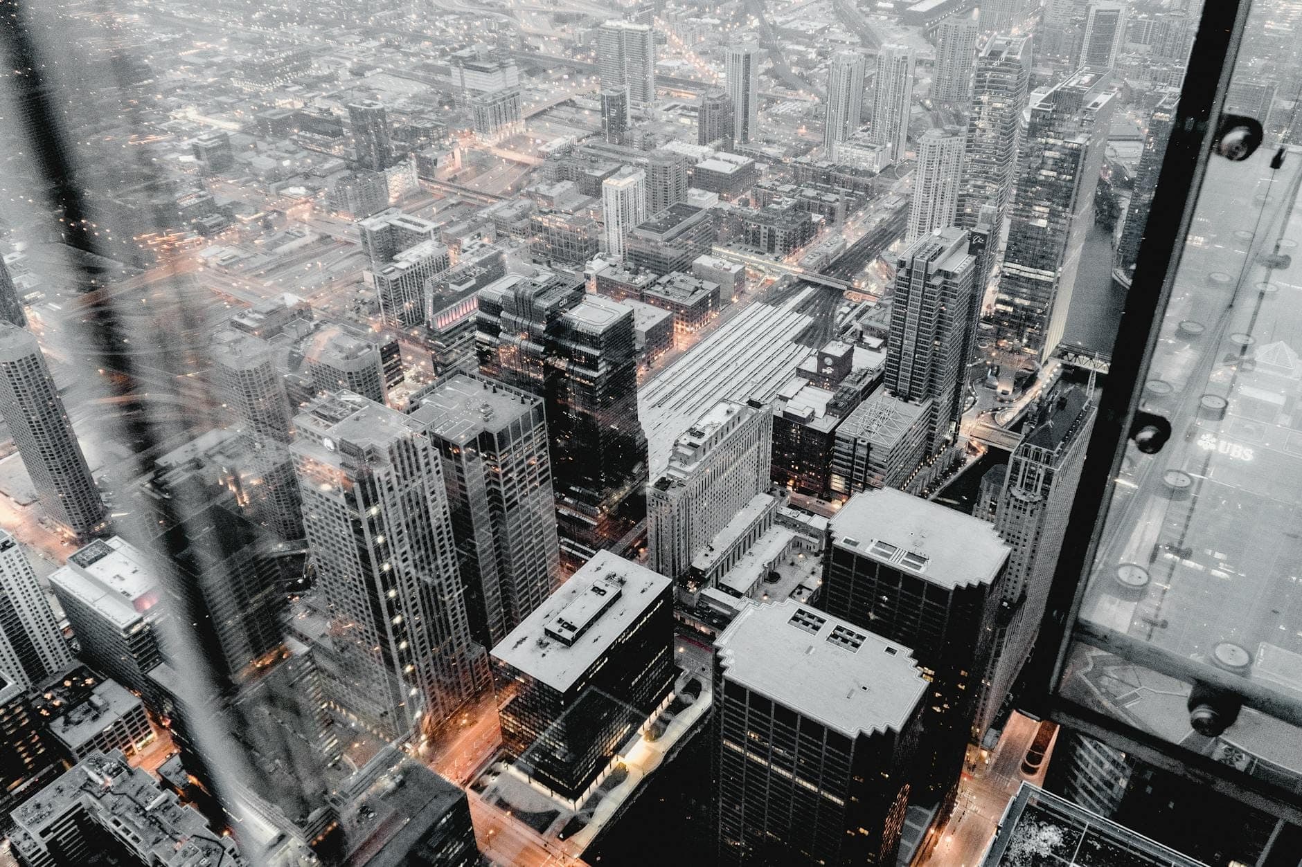 View looking straight down at Chicago city skyscrapers through glass floor, from a high observation deck