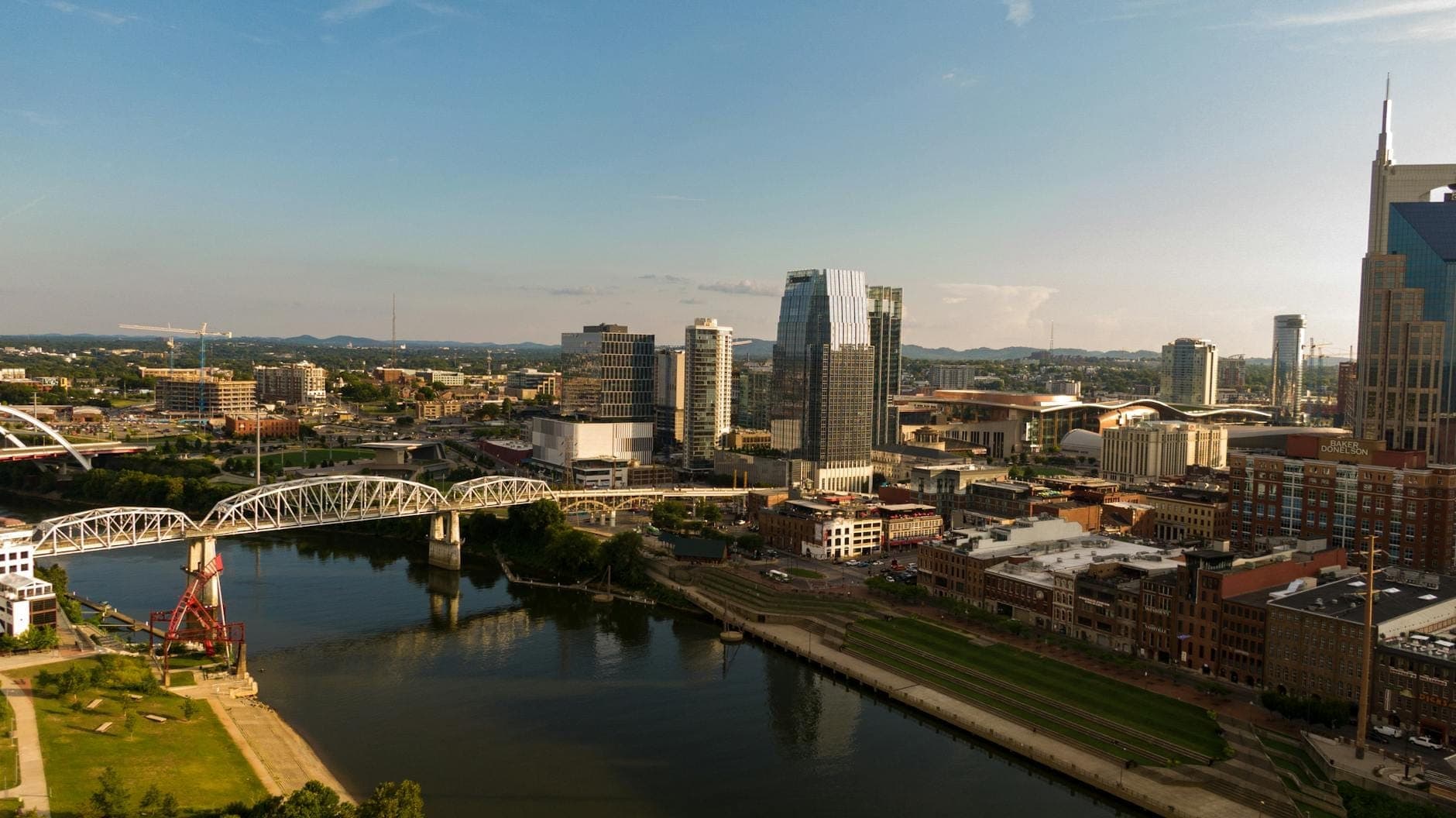 Luftaufnahme der Innenstadt von Nashville mit Flussufer, Brücken und Skyline an einem sonnigen Tag, ideal für Open-Air-Festivalveranstaltungen.