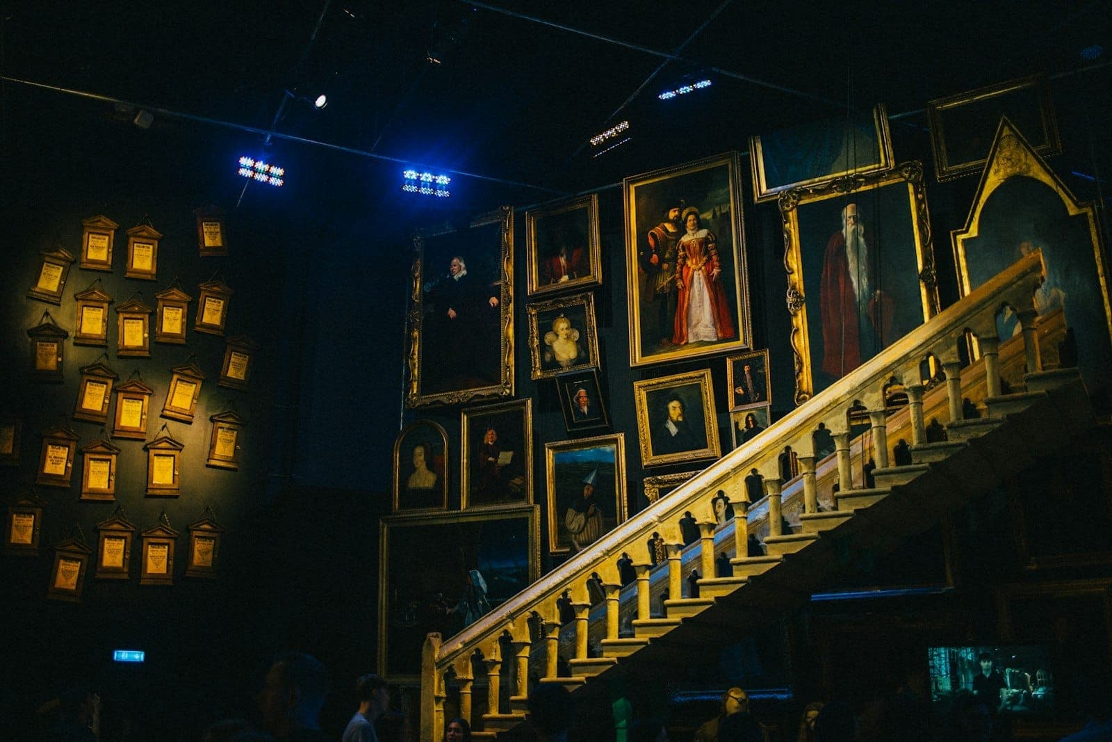 Eine Treppe, gesäumt von leuchtenden Porträts im Inneren der Harry Potter Studio Tour, mit ikonischer magischer Dekoration und Atmosphäre.