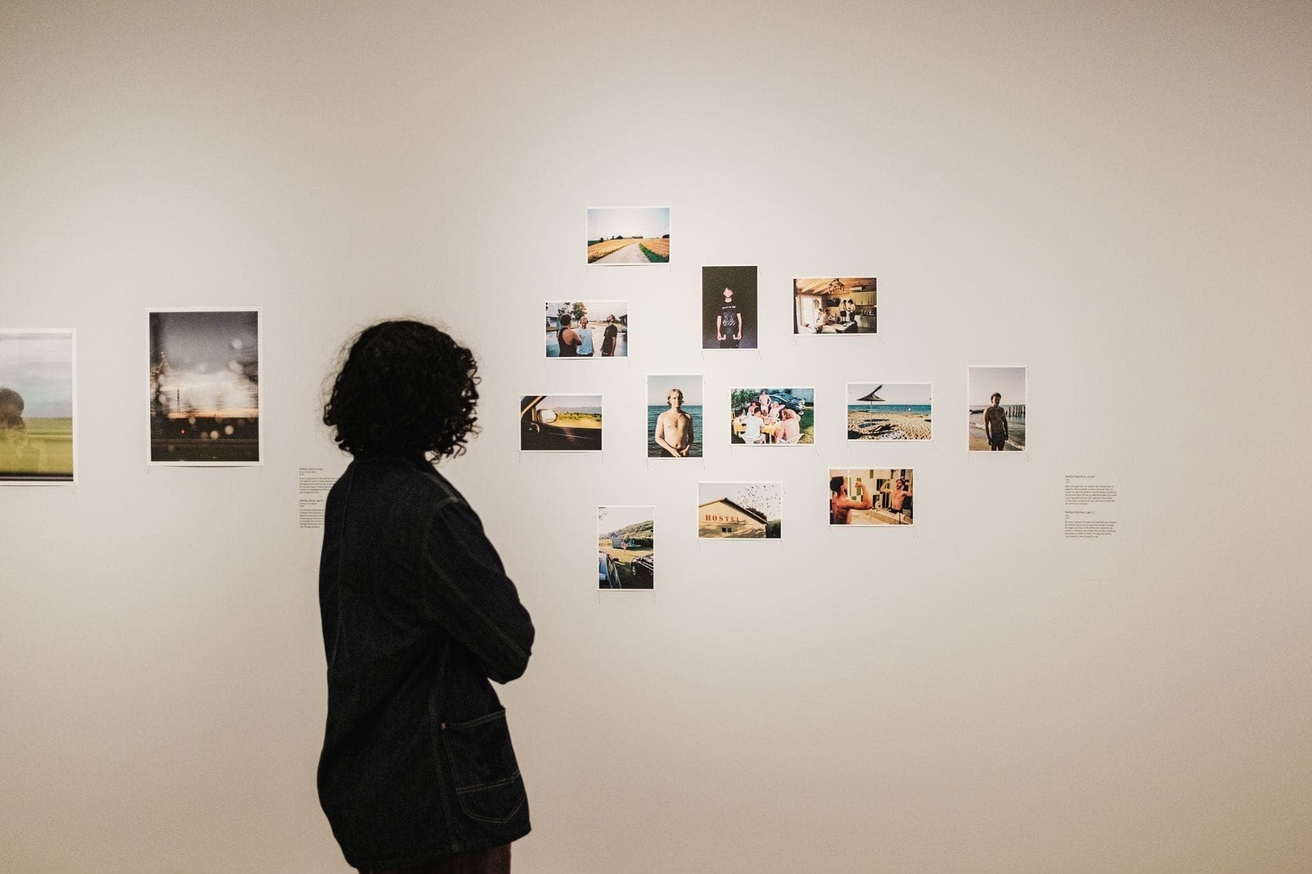 Ein Besucher betrachtet eine weiße Galeriewand mit farbenfrohen Fotografien im FOAM Photography Museum in einem Keizersgracht-Kanalhaus in Amsterdam.