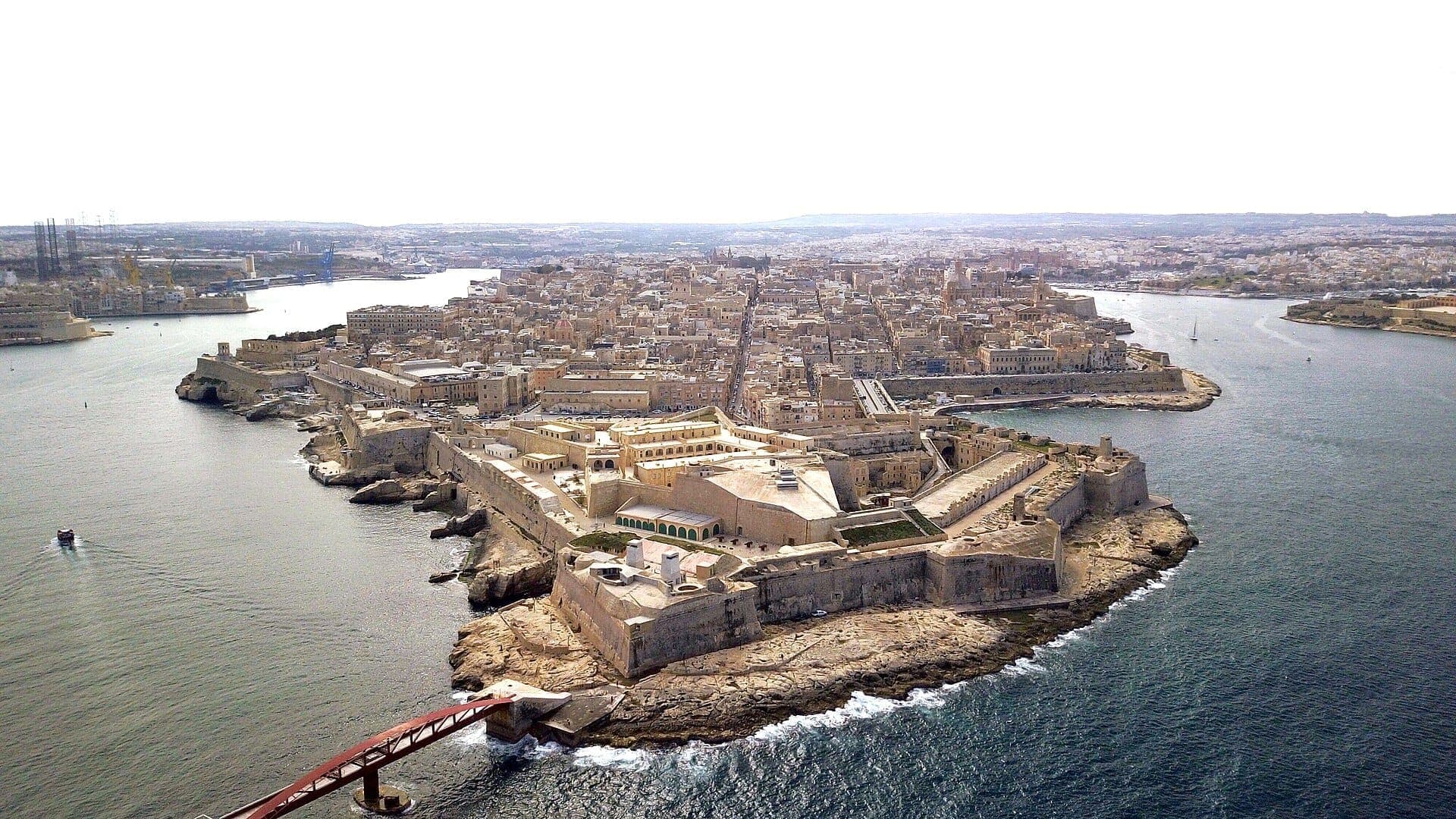 Luftaufnahme von Fort St. Elmo und der historischen Stadtsilhouette von Valletta, umgeben von blauen Uferfronten und Steinwällen an der Spitze der Halbinsel.