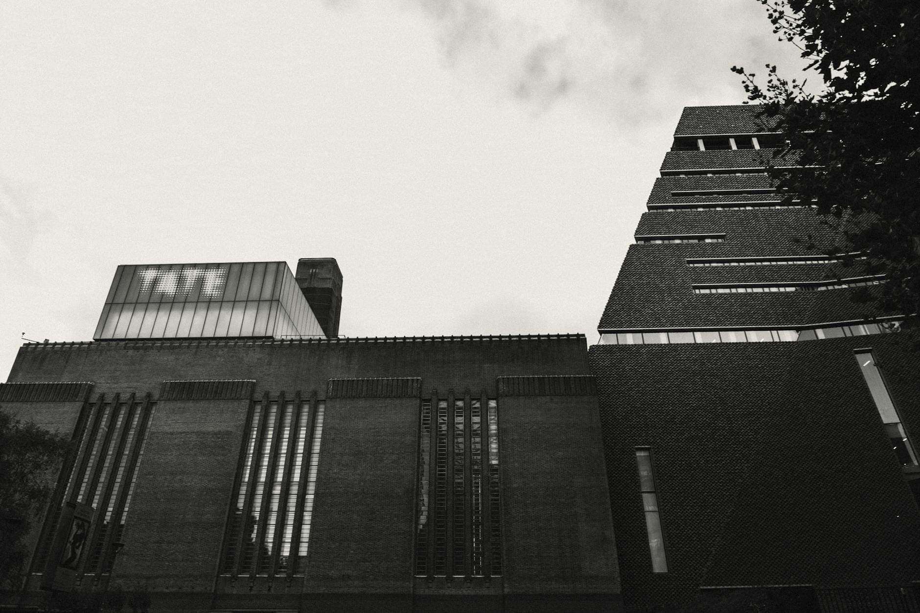 Schwarz-Weiß-Foto des Außenbereichs der Tate Modern in London, mit dem TATE-Schriftzug am Gebäude.