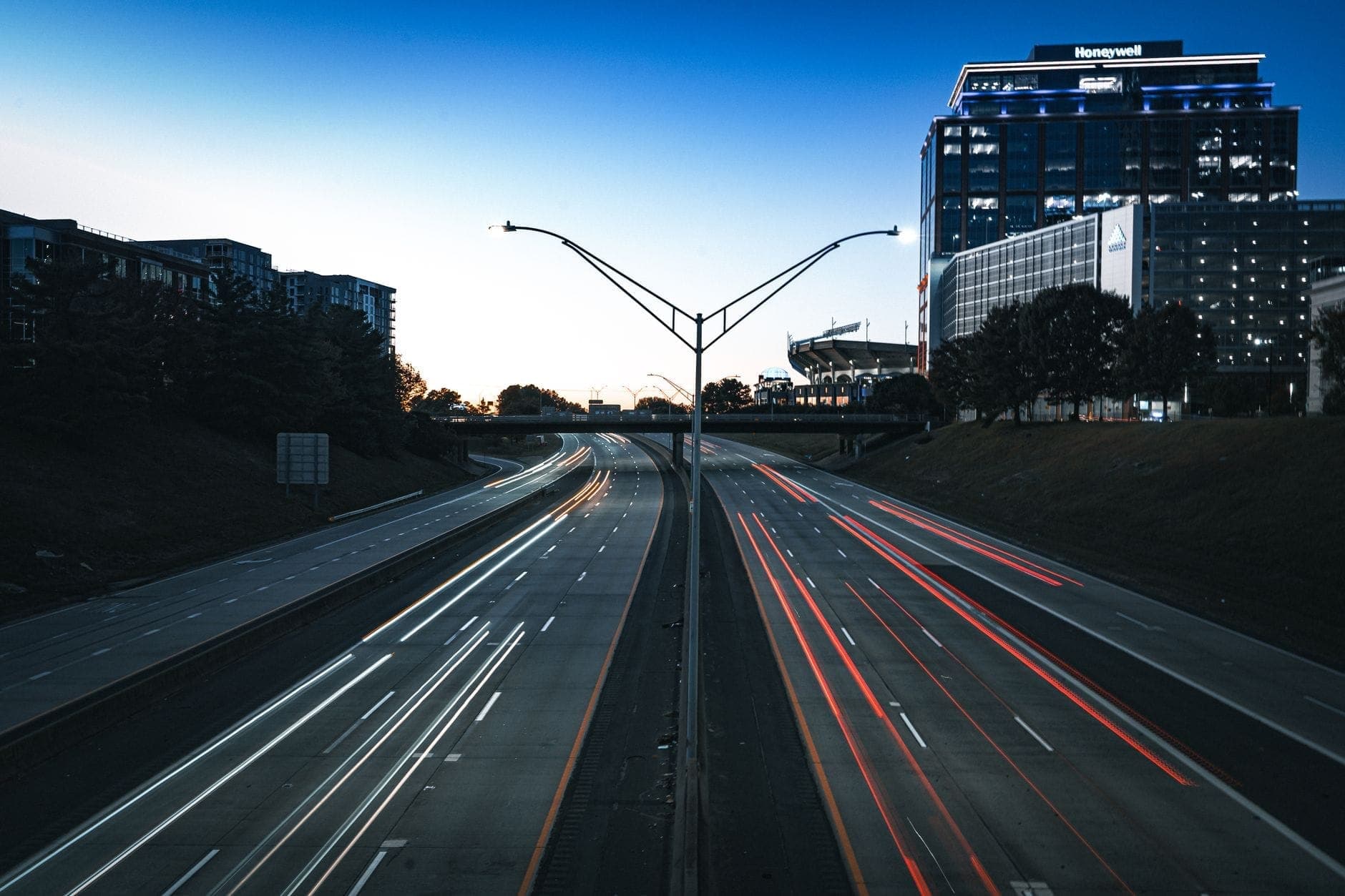 Städtische Autobahn am Abend in Nashville mit modernen Gebäuden und Lichtspuren des Verkehrs auf beiden Seiten der Straße.
